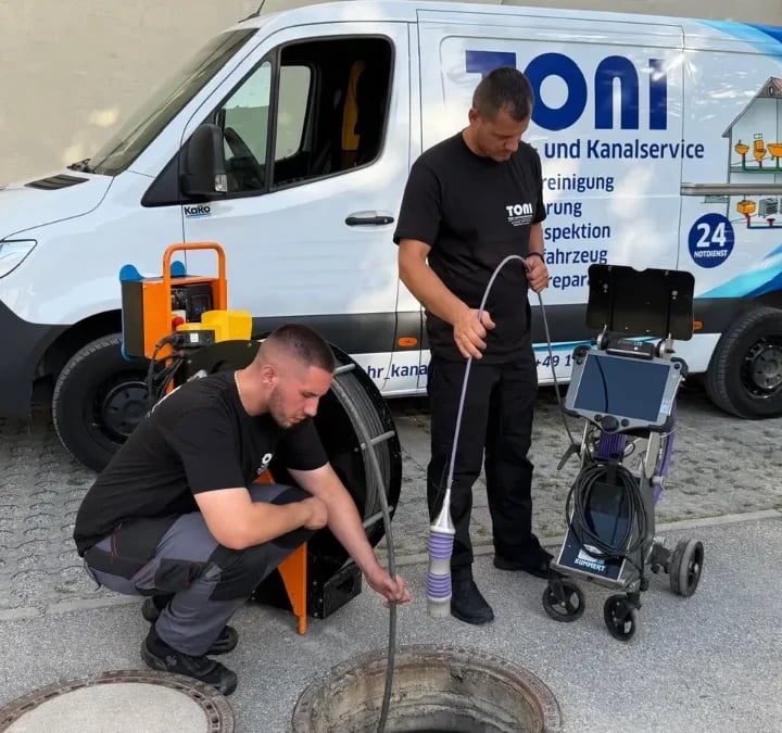 Techniker von TONI Rohr- und Kanalservice bei einer Kanal-TV-Inspektion am geöffneten Schacht